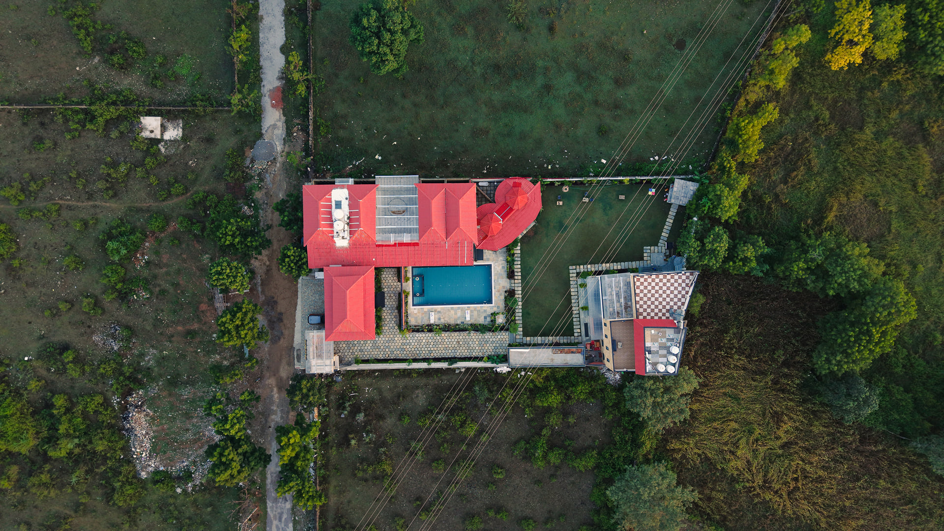Top-down view of Nazaara Hills Retreat's red-tiled roofs set into the Aravalli hillside, Udaipur
