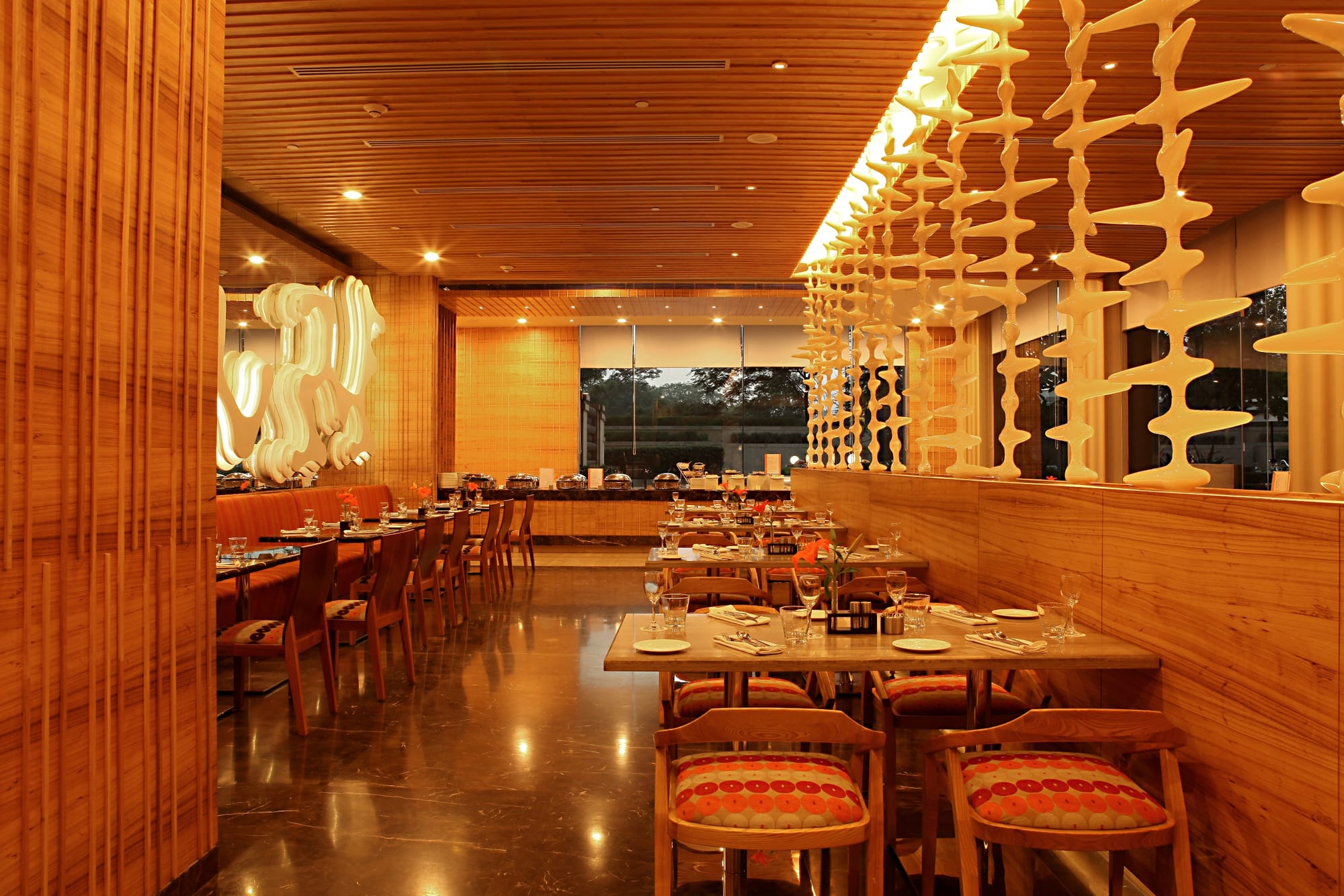 The dining room at Zing, its sculptural screen lit above laid tables