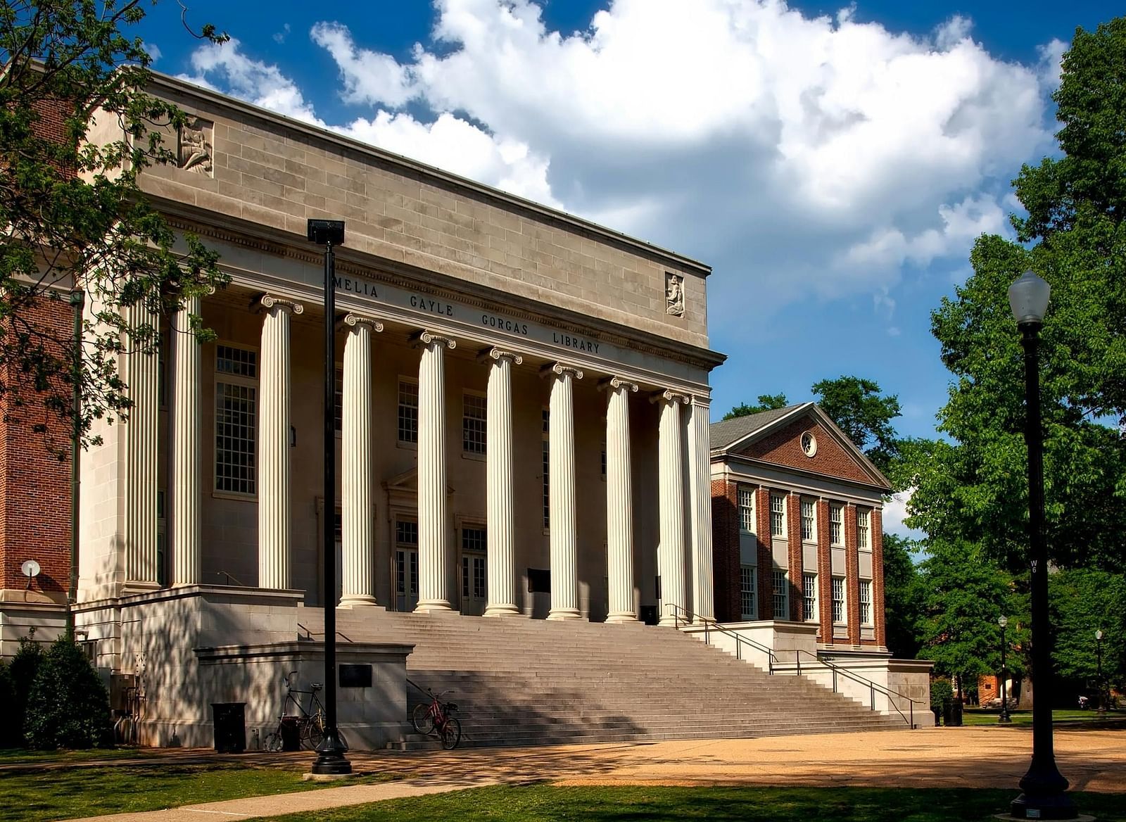 A grand, classical-style building with large white pillars and a wide stone staircase leading up to it.