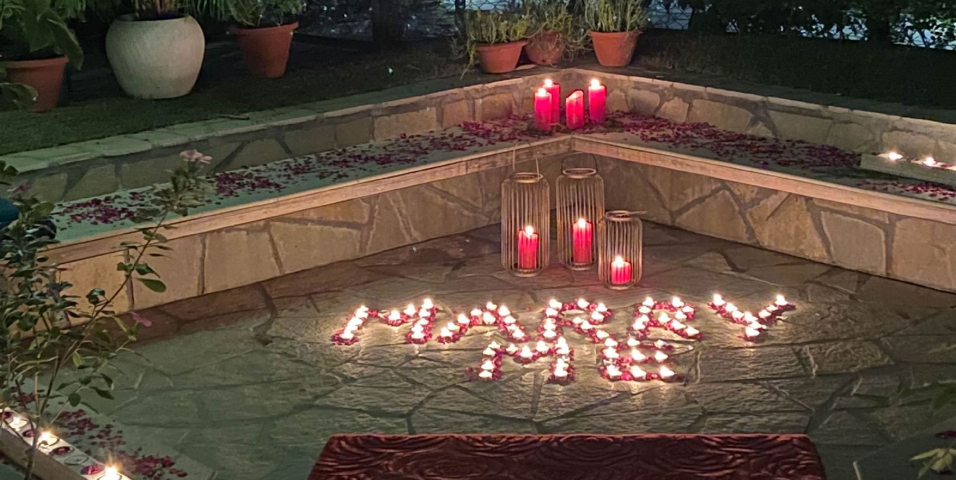 Outdoor dining table lit with red candles at night | Karma Chalets