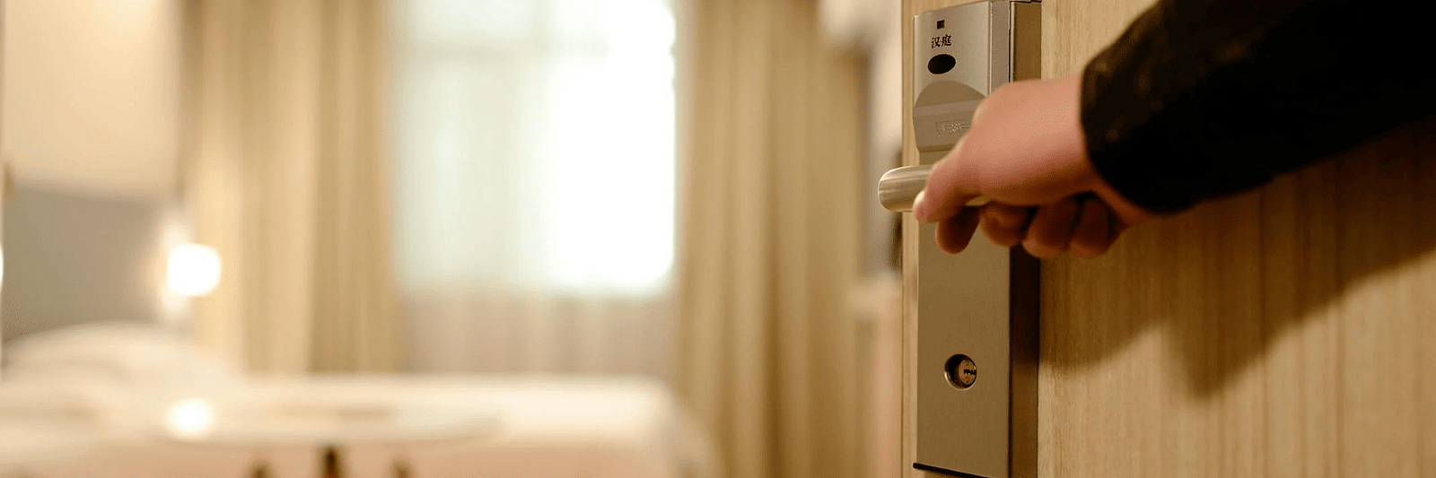A person opeing the door to a bedroom