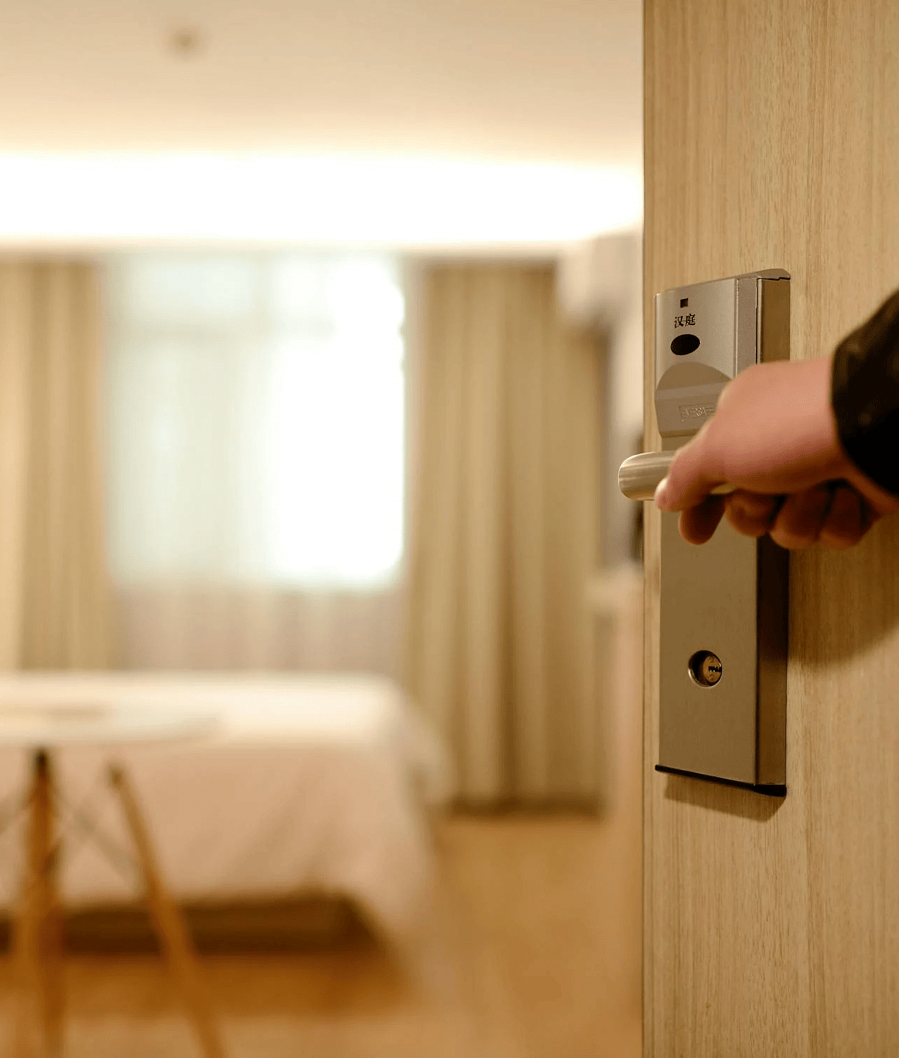 A person opeing the door to a bedroom