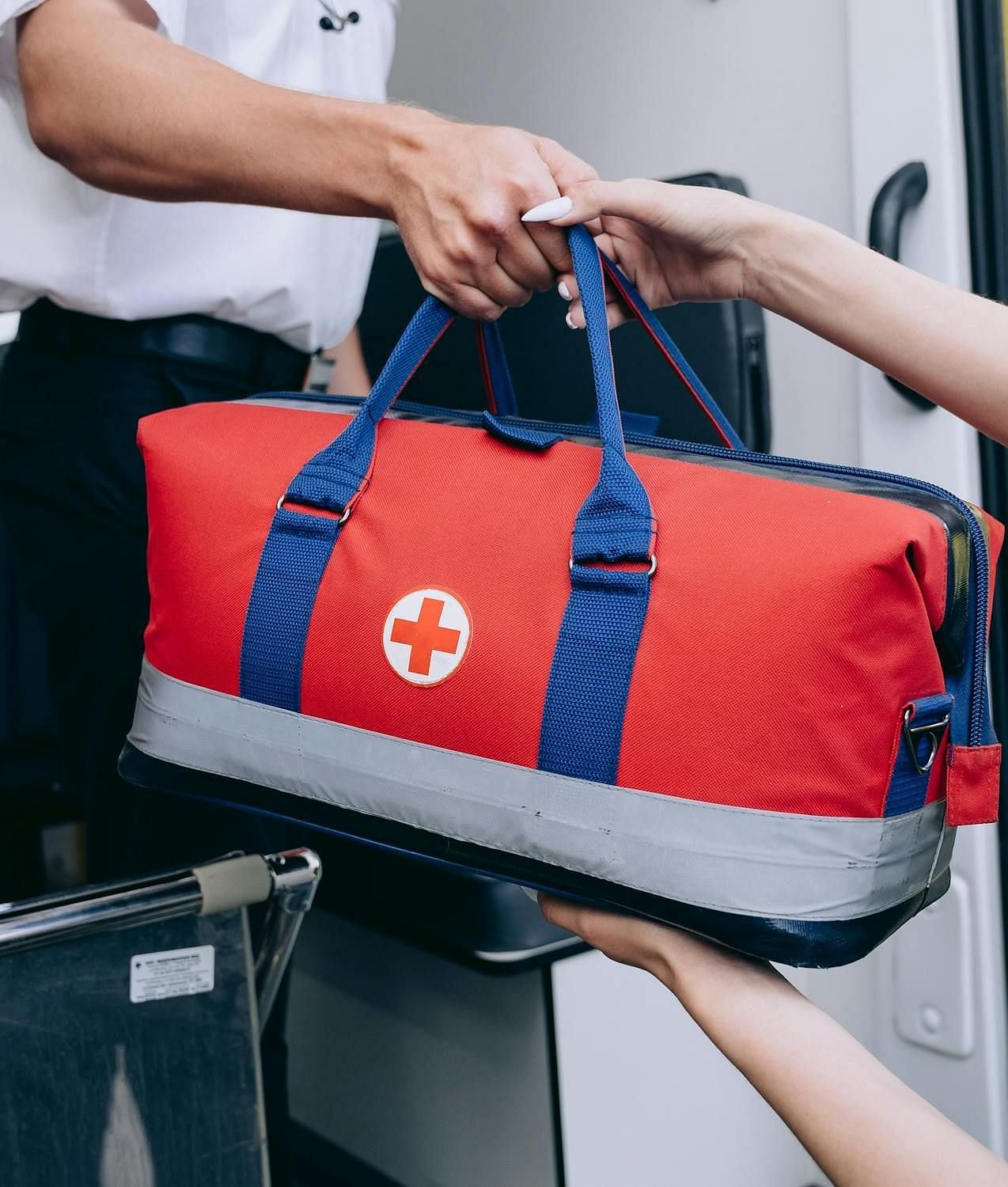 A person handing out a bag of first aid kid to another person
