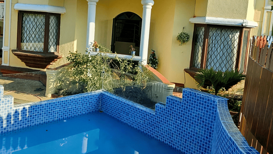 Full-view shot of the exterior of Amara Villa, Nagoa, featuring a swimming pool in front of the villa on a bright sunny day.