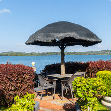 Image of an outdoor seating area with the view of a waterbody in front.