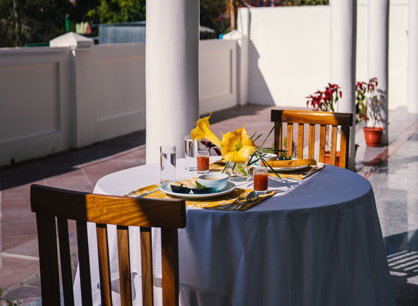 A table for two, neatly set for dining on the balcony at BluSalzz Villas - The Green Roof, Bhimtal.