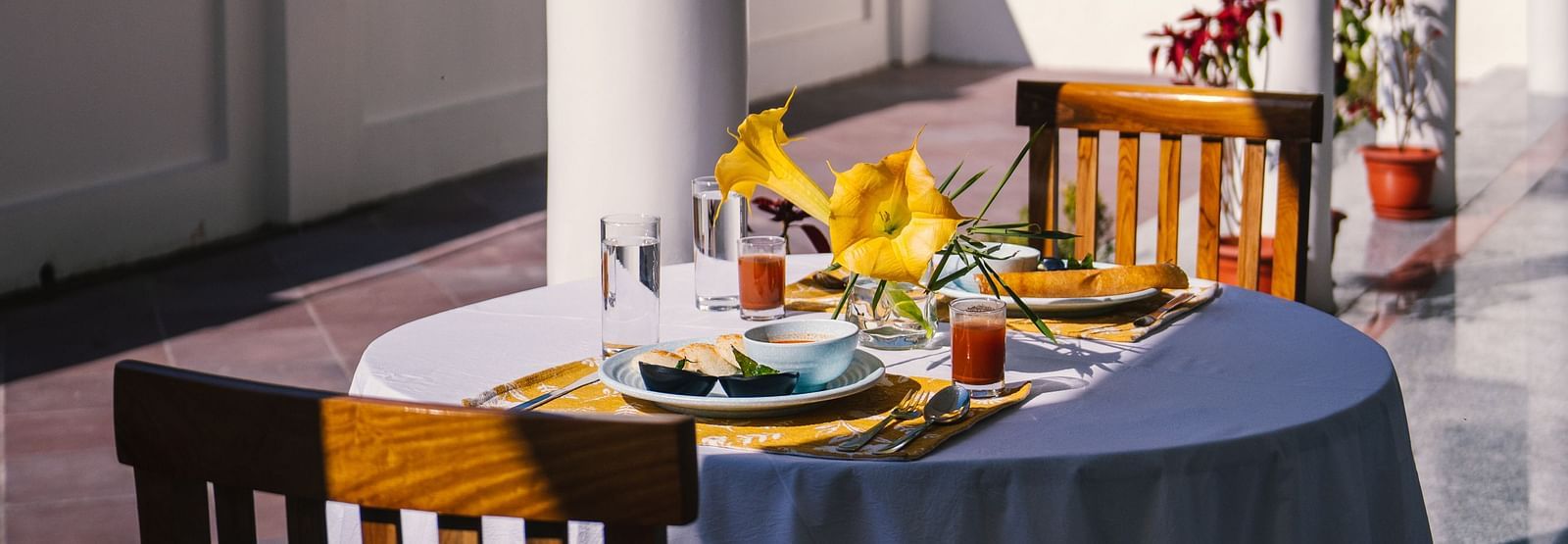 A table for two, neatly set for dining on the balcony at BluSalzz Villas - The Green Roof, Bhimtal.