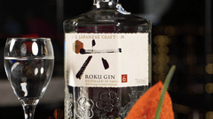 Table setting with a bottle, wine glasses, and fruit at Asiatic Rooftop Bar and Restaurant.