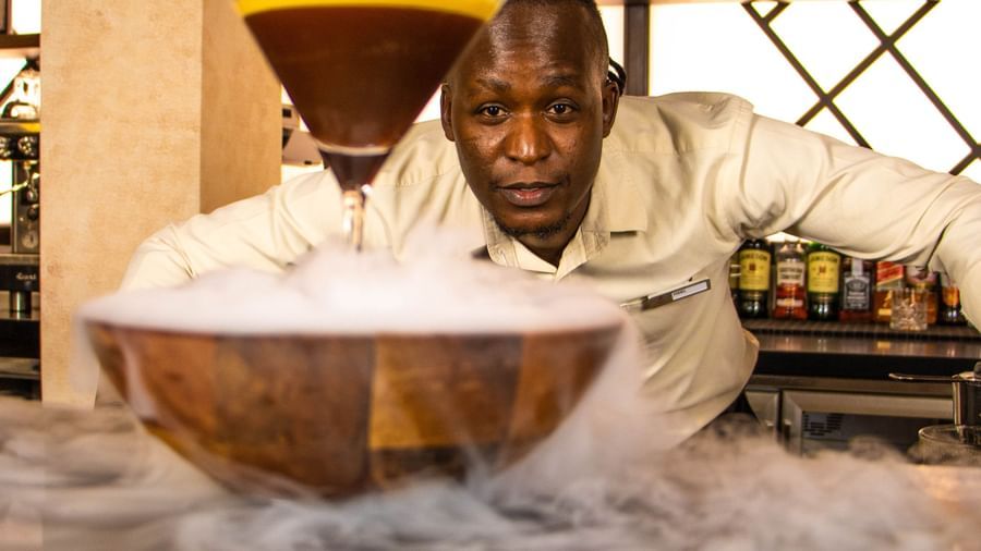 A corner angle of a glass bowl with dry ice placed on a bar counter, cocktail glass positioned on the bowl at Asiatic Lounge.