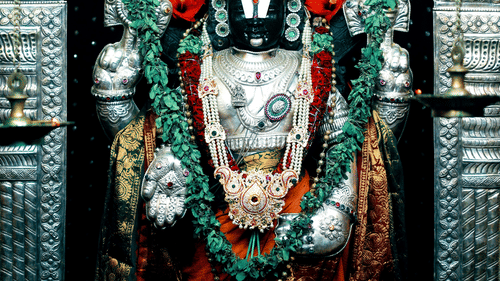 A detailed, colourful statue of Lord Venkateshwara in a temple.