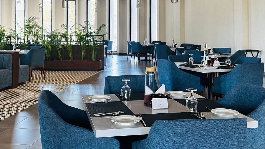  Ananta Spa and Resort Ajabgarh | Dining area with blue chairs, set tables, and arched design.
