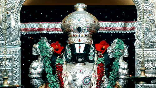 A detailed, colourful statue of Lord Venkateshwara in a temple.