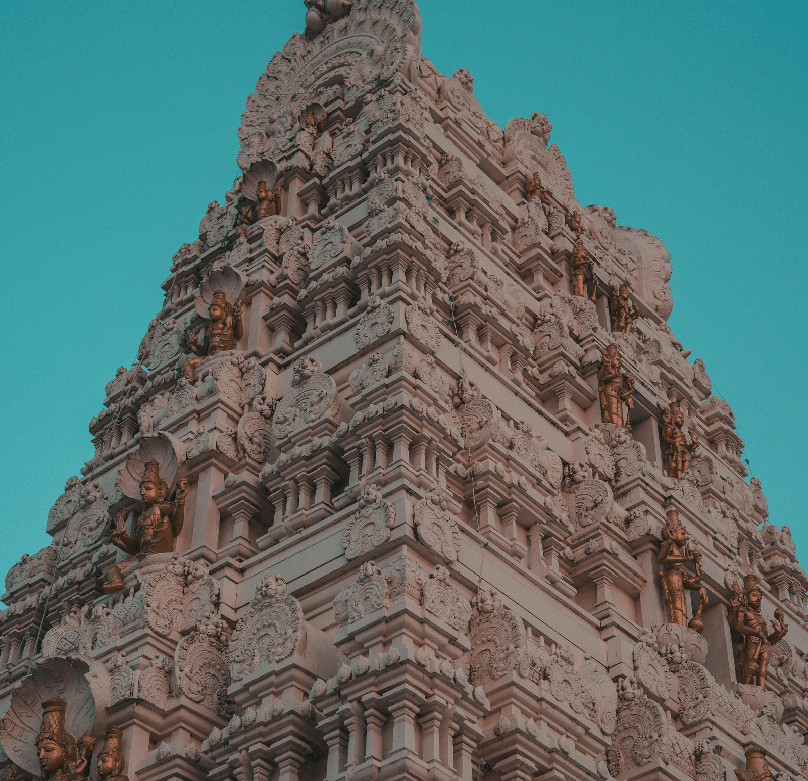 A low-angle view of the intricately carved gopuram of Sri Subramaniya Swamy Temple.
