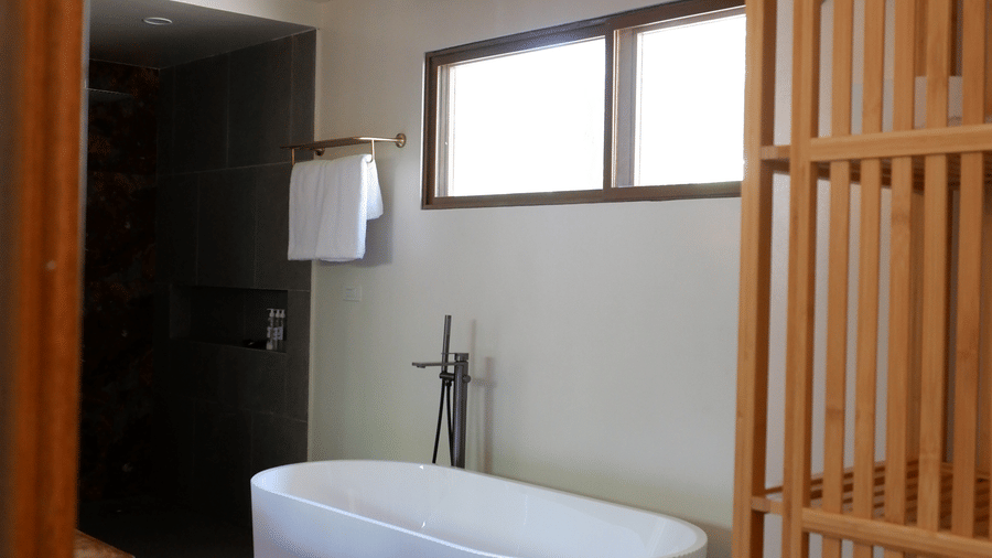 Flower Island Resort | A bathroom space with bathtub, toilteries and a wooden door.