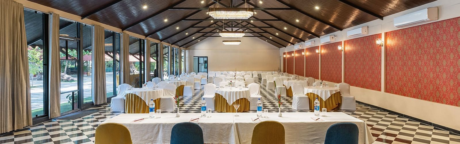 image featuring an expansive banquet hall from the back of the table that receives ample natural light from the window panel on the left