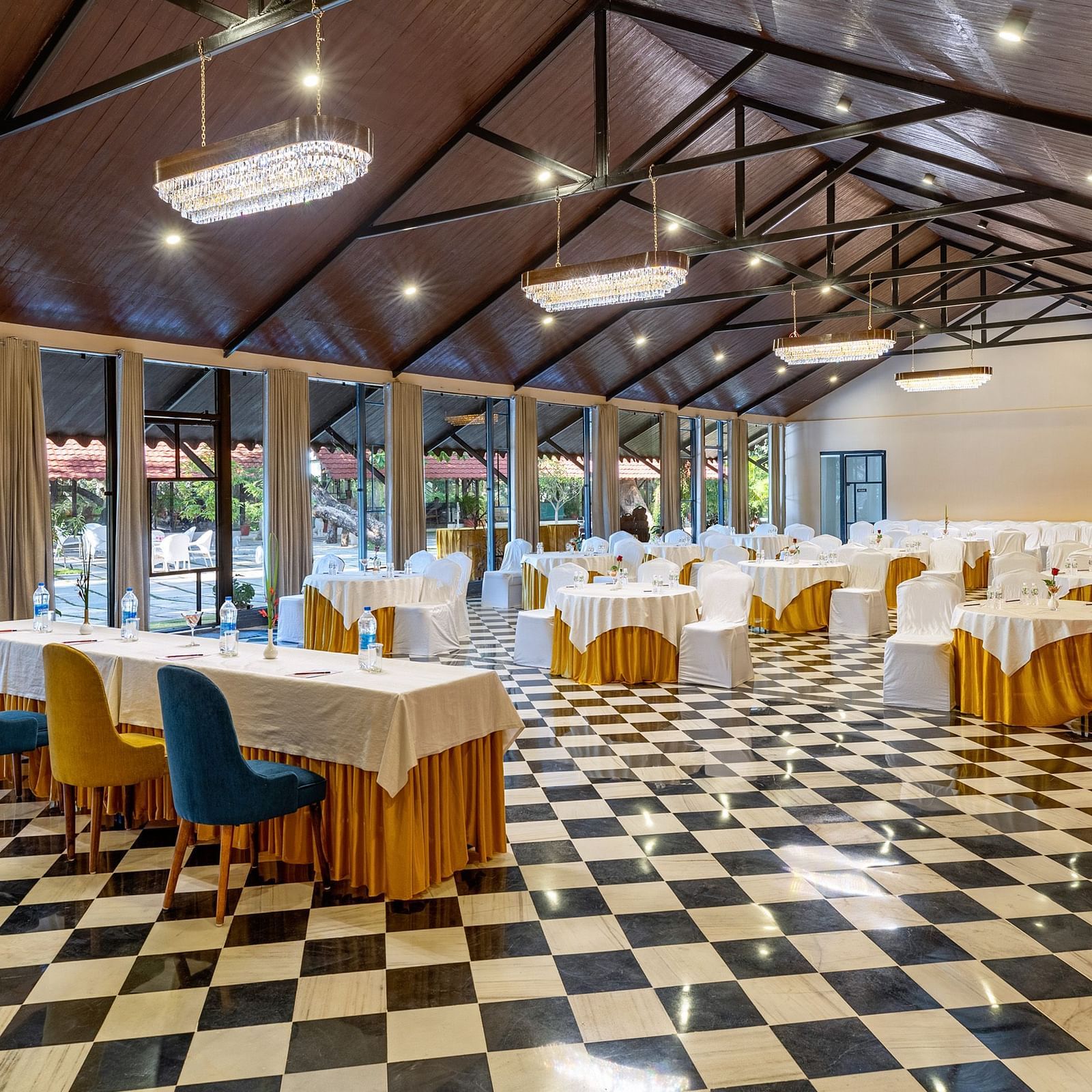 corner view of the banquet hall in udaipur with a high ceiling and properly arranged chairs and tables