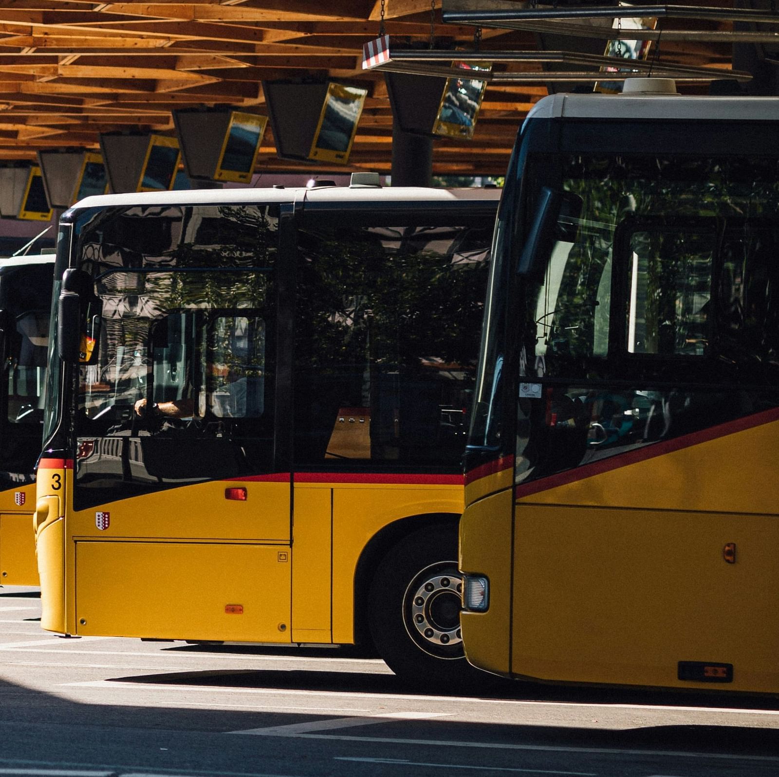 Buses standing in bus stand in a row.