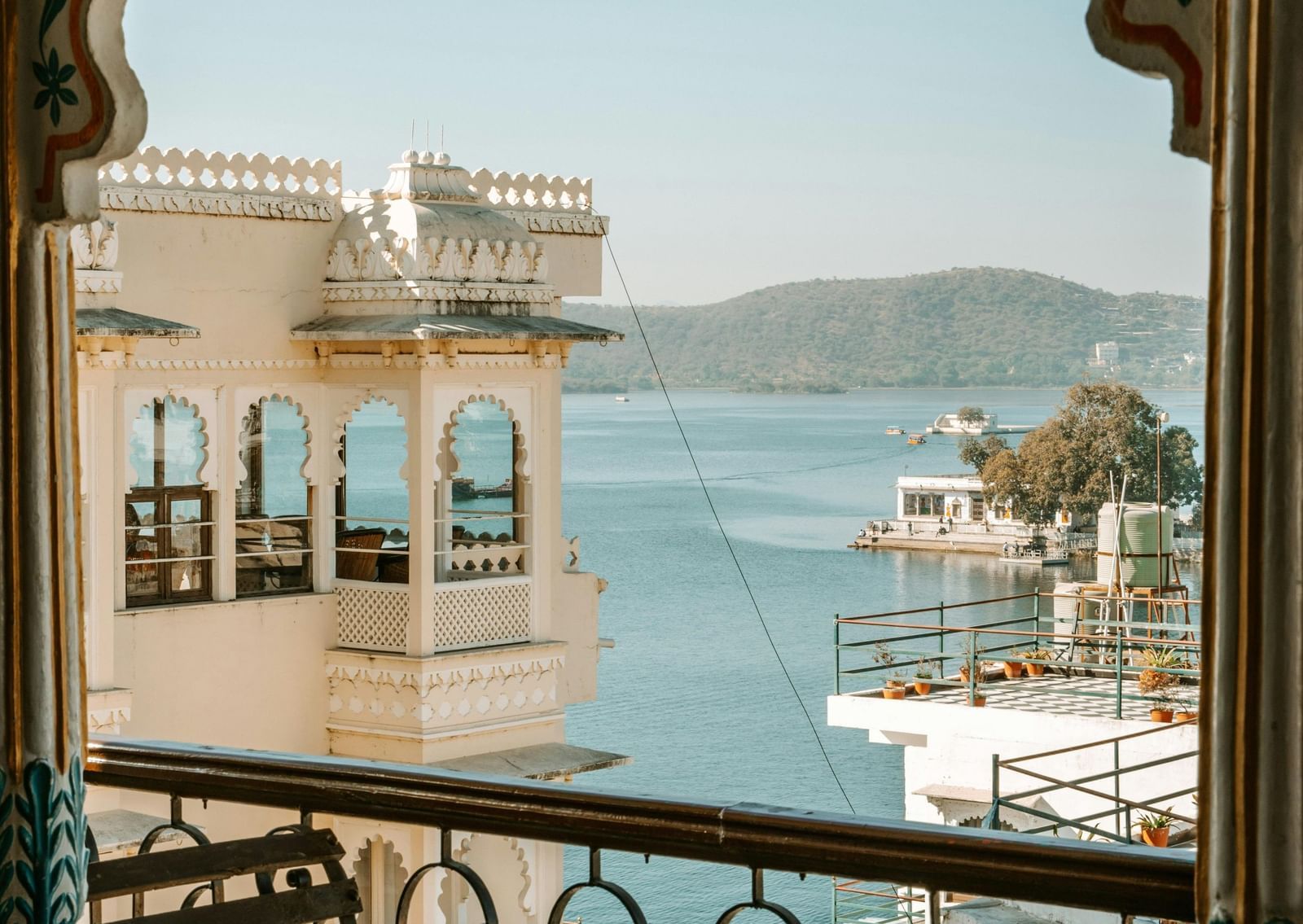 Ornate arched balcony overlooking Lake Pichola with chairs for viewing the scenery.
