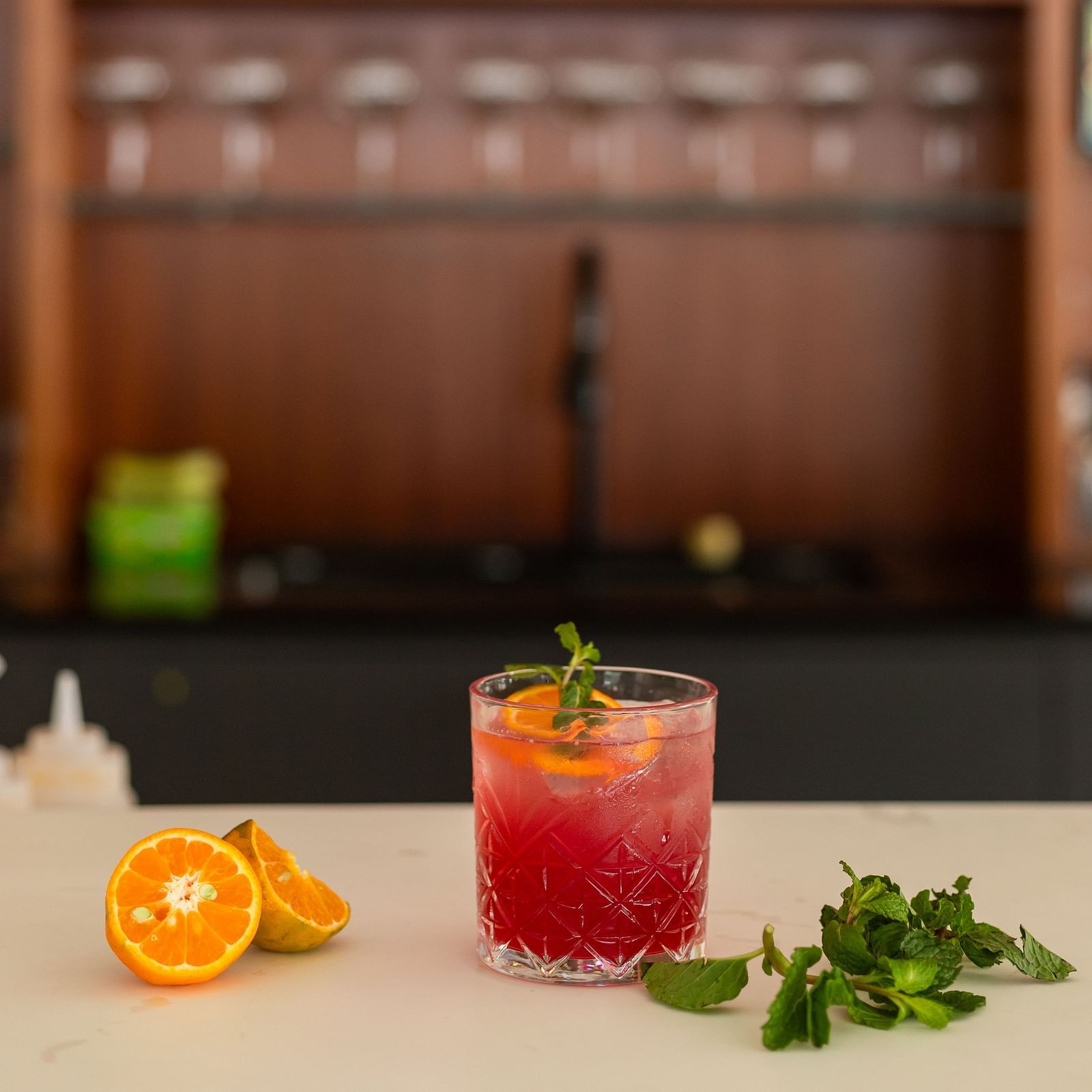 Mint placed beside a glass of red cocktail placed on a counter at Mandala Norling Lords Prime, Kathmandu.