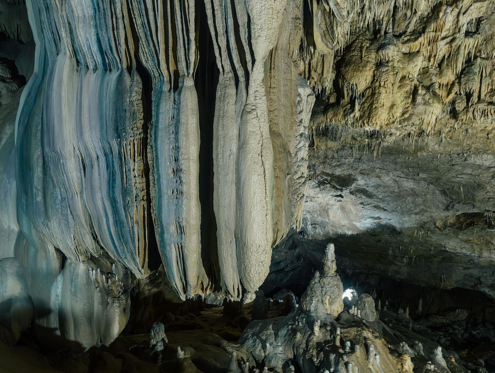 a cave with majestic stalactite deposits formed over time from the ceiling.