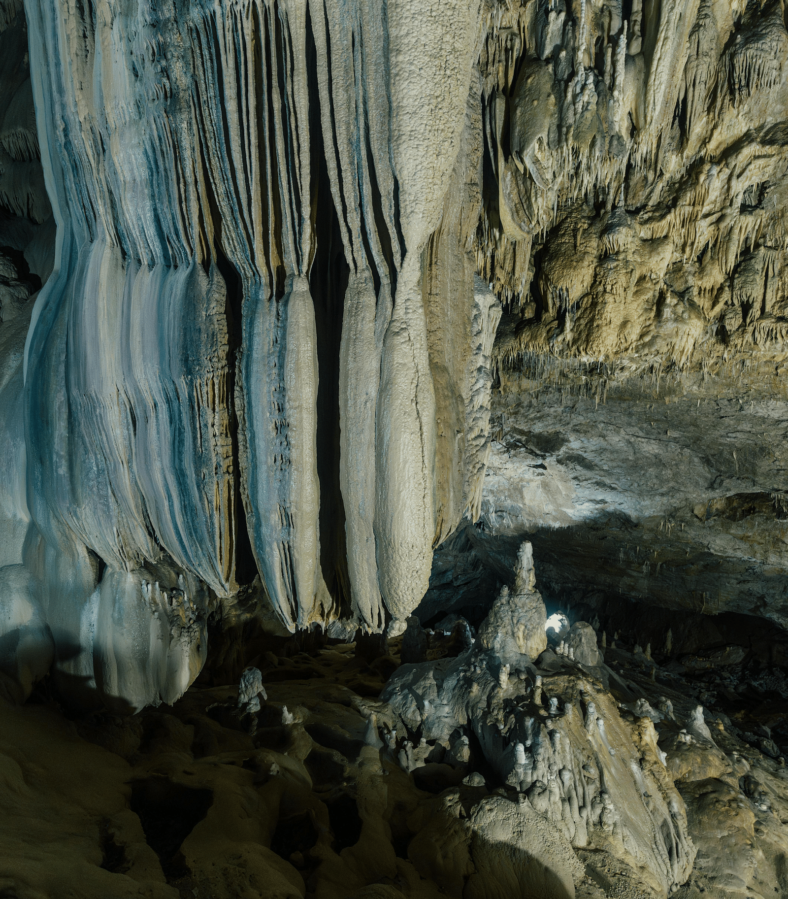 a cave with majestic stalactite deposits formed over time from the ceiling