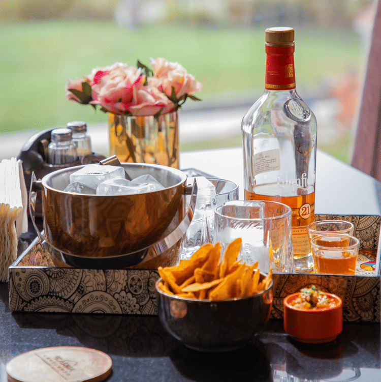 A close up shot of a table with a bottle and many food items on it - Karma Lakelands.