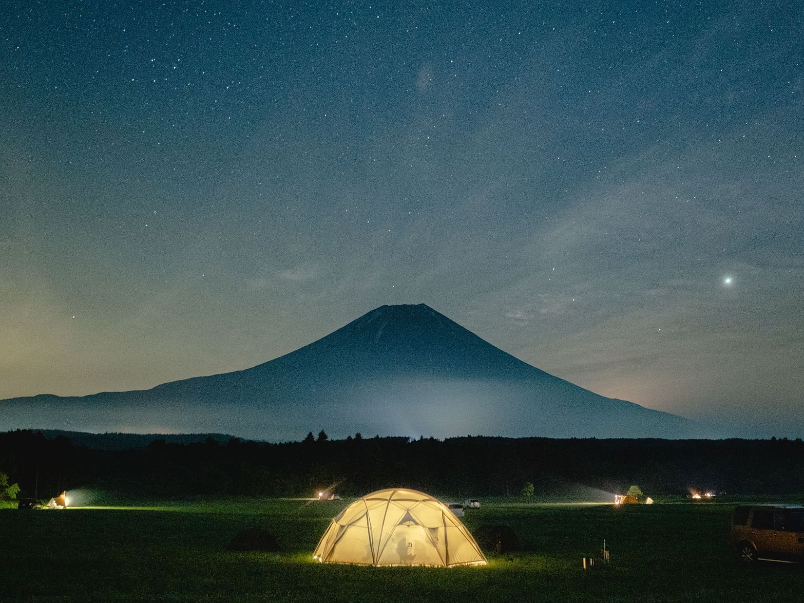 a lit up tent at dusk