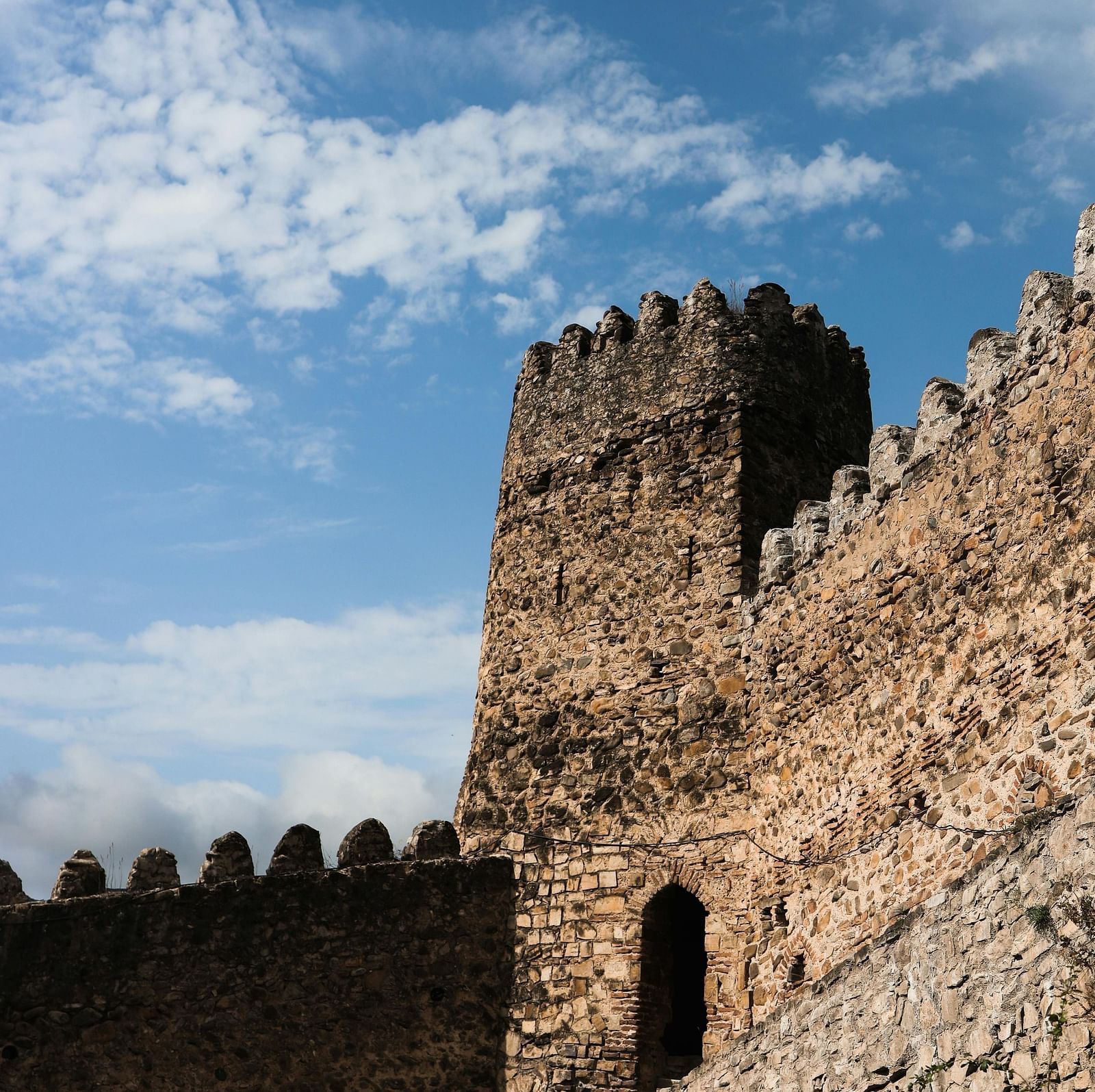 A low angle shot of a fort with high towers seen during a sunny day
