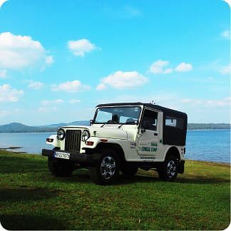 Image of a jeep with a waterbody behind.