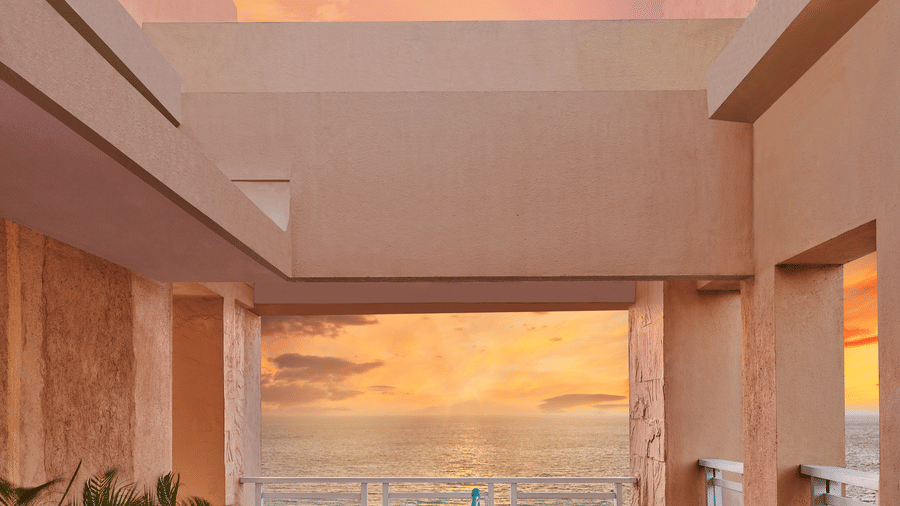 Open terrace dining setup at The Resort, Mumbai overlooking the sea during sunset, with a table for two, warm lighting, and coastal views creating a relaxed ambience.