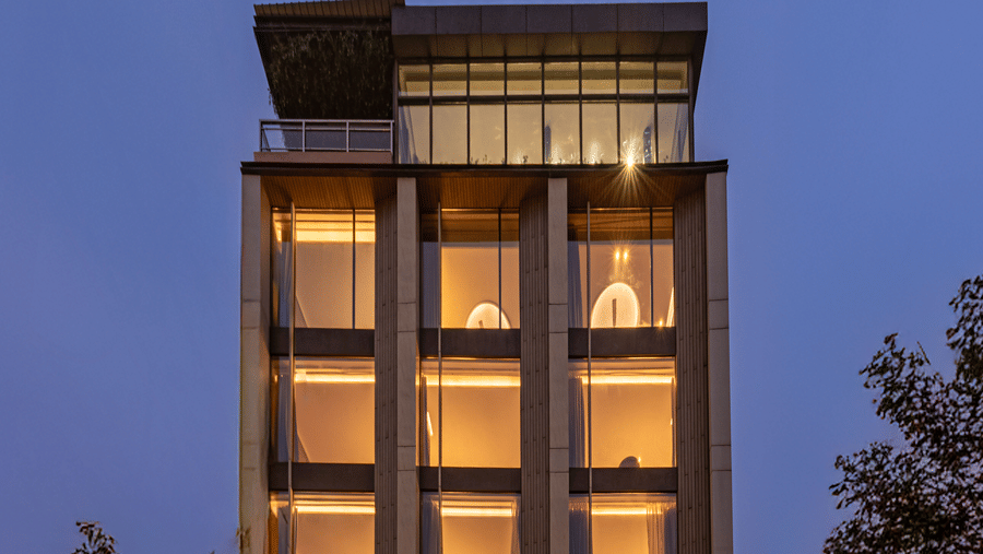 A multi storey building with lit windows viewed from outside during evening at DLS Hotels Amritsar.