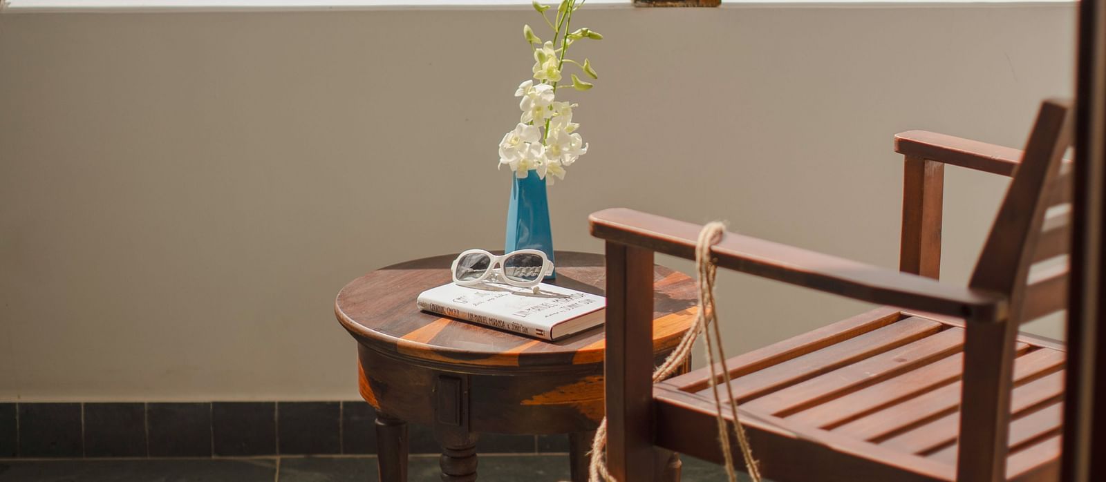 A balcony with a wooden chair facing a landscape view - Alibu Resort