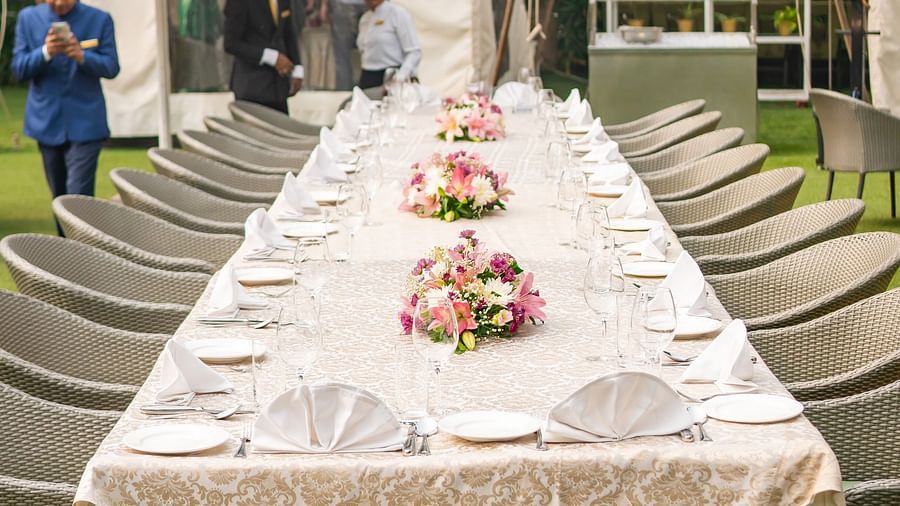image of a long dining table decorated with cutlery at the claridges garden - The Claridges New Delhi