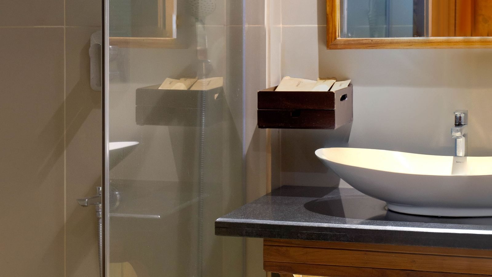 Image of the bathroom of Coral Turquoise at Coral Reef Resort and Spa in Havelock featuring a sink with a mirror over it and the shower space next to it separated by a glass door