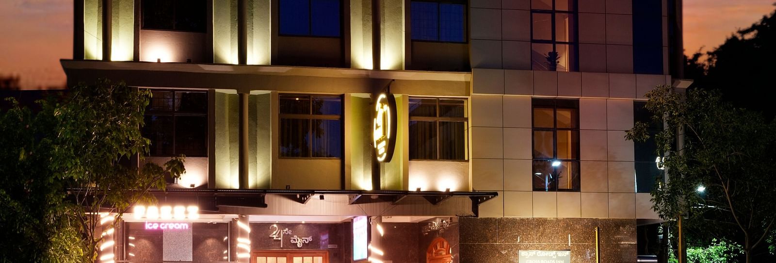 A night view of our hotel building illuminated by warm lights - Cross Roads Inn, Bengaluru