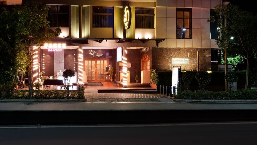 A night view of our hotel building illuminated by warm lights - Cross Roads Inn, Bengaluru