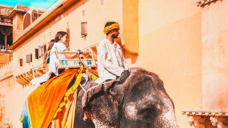 Elephant ride near a fort, with the rider dressed in traditional attire.