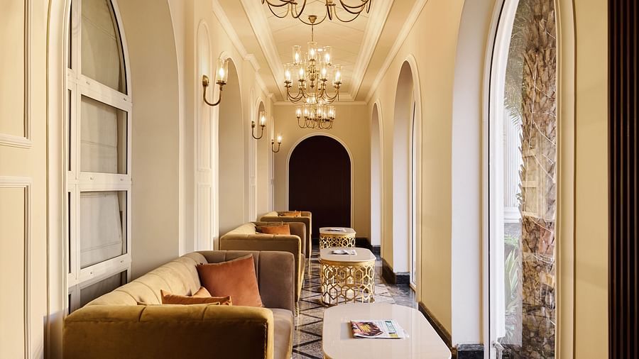 chandeliers hanging over sofas and coffee tables in a corridor - Royal Kingdom Sarovar Portico, Pilibhit