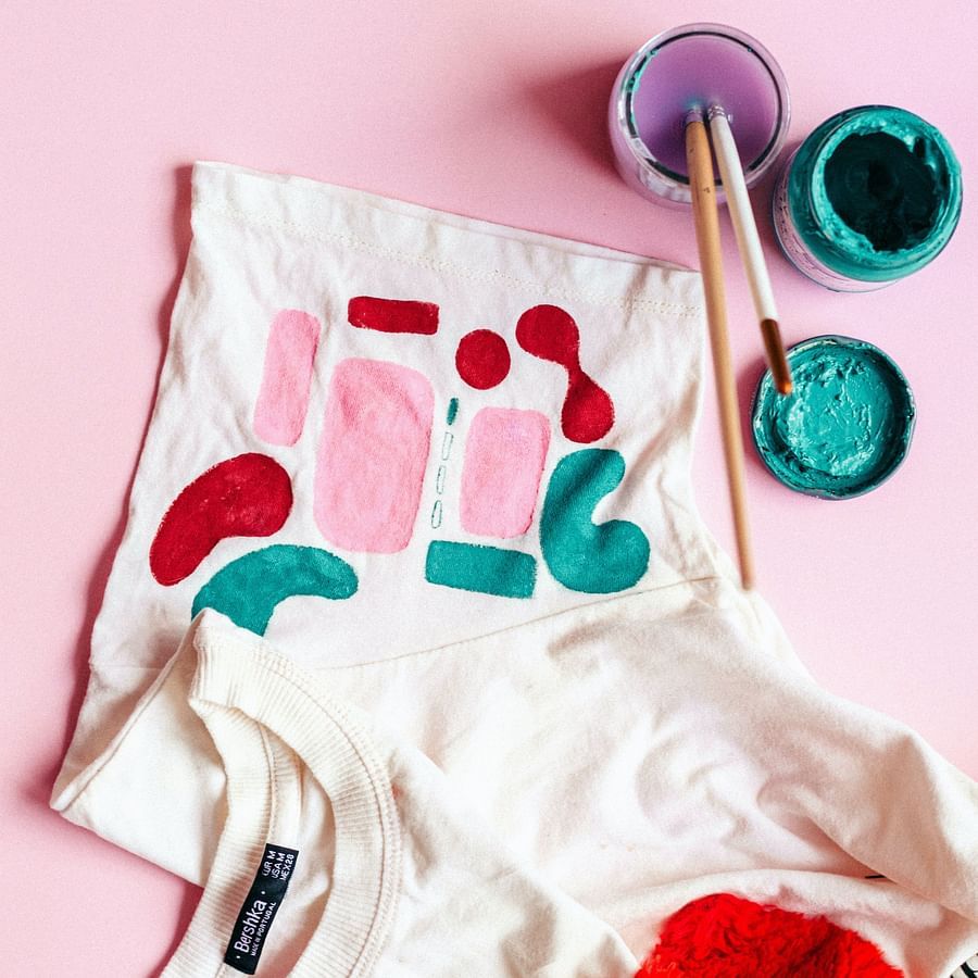 t-shirt with paints and brushes around it