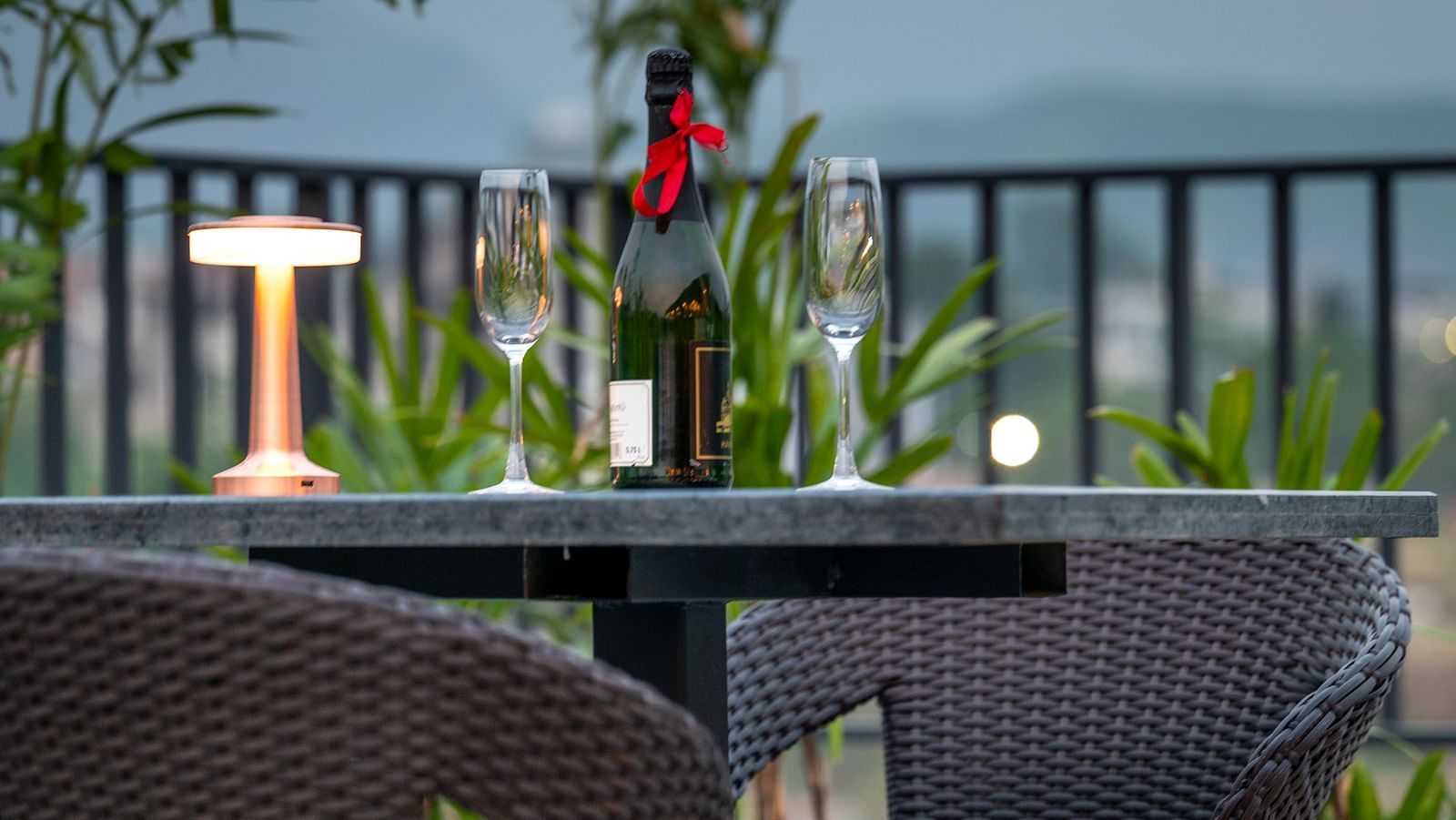 Outdoor patio area with dark furniture and greenery at Vishranti Hotel, Dehradun. 