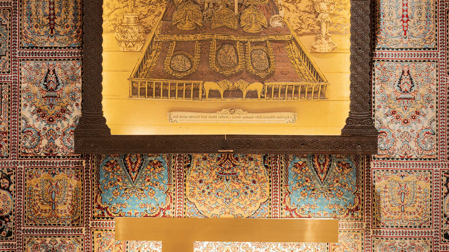 A glowing decorative wall piece featuring traditional religious iconography and script at Ananta Express, Katra.