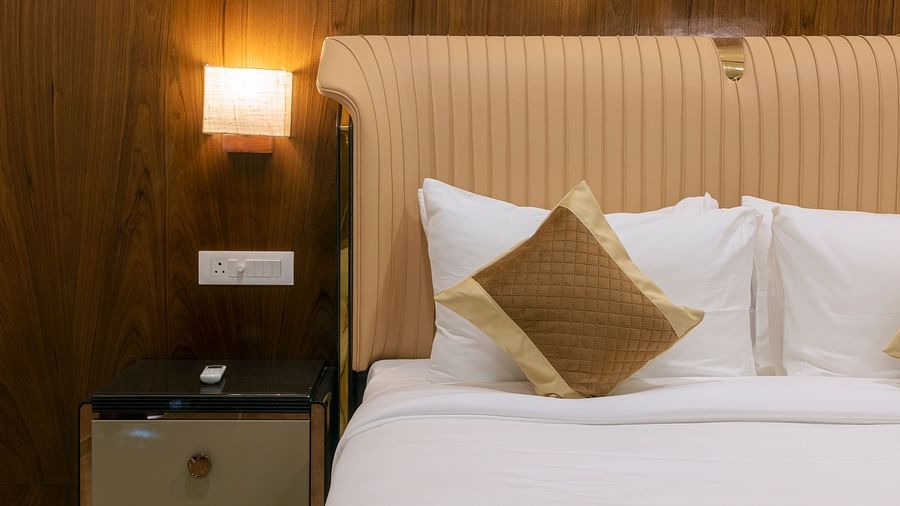 A double bed with side tables and lamps inside the Suite - VITS Satyajeet Karad