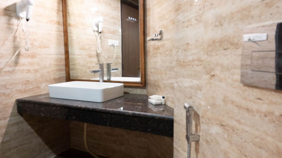 A bathroom with a wash basin and hair dryer at Avianna Hungry Jack, Gangtok.
