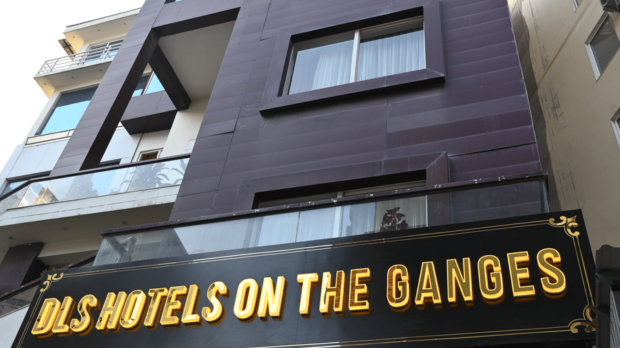 Exterior view of DLS Hotels on the Ganges, showcasing the multi-story purple building, the hotel signage in bold yellow letters, and the surrounding urban environment, giving a clear impression of the hotel’s façade