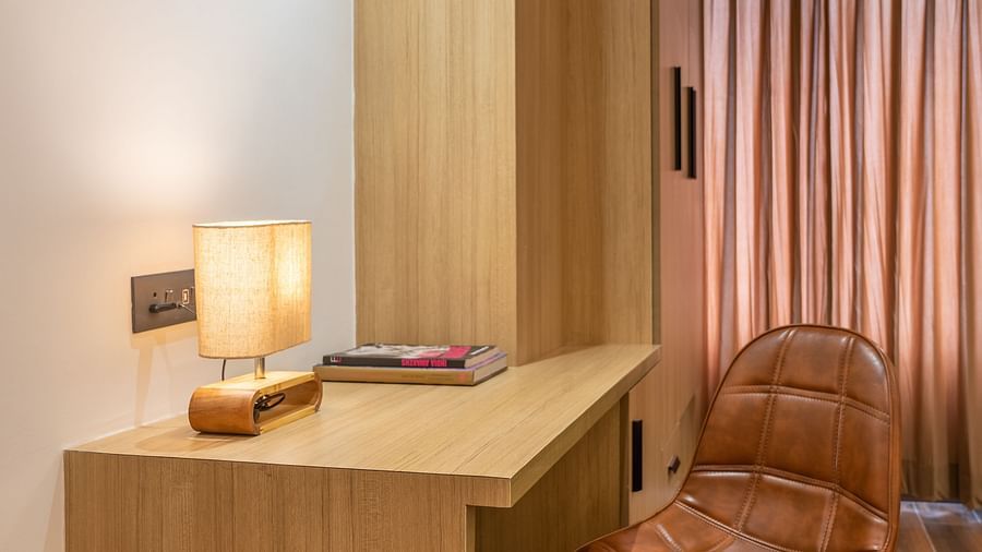 Close up of a work desk and chair arrangement with warm lighting at Vishranti Hotel, Dehradun