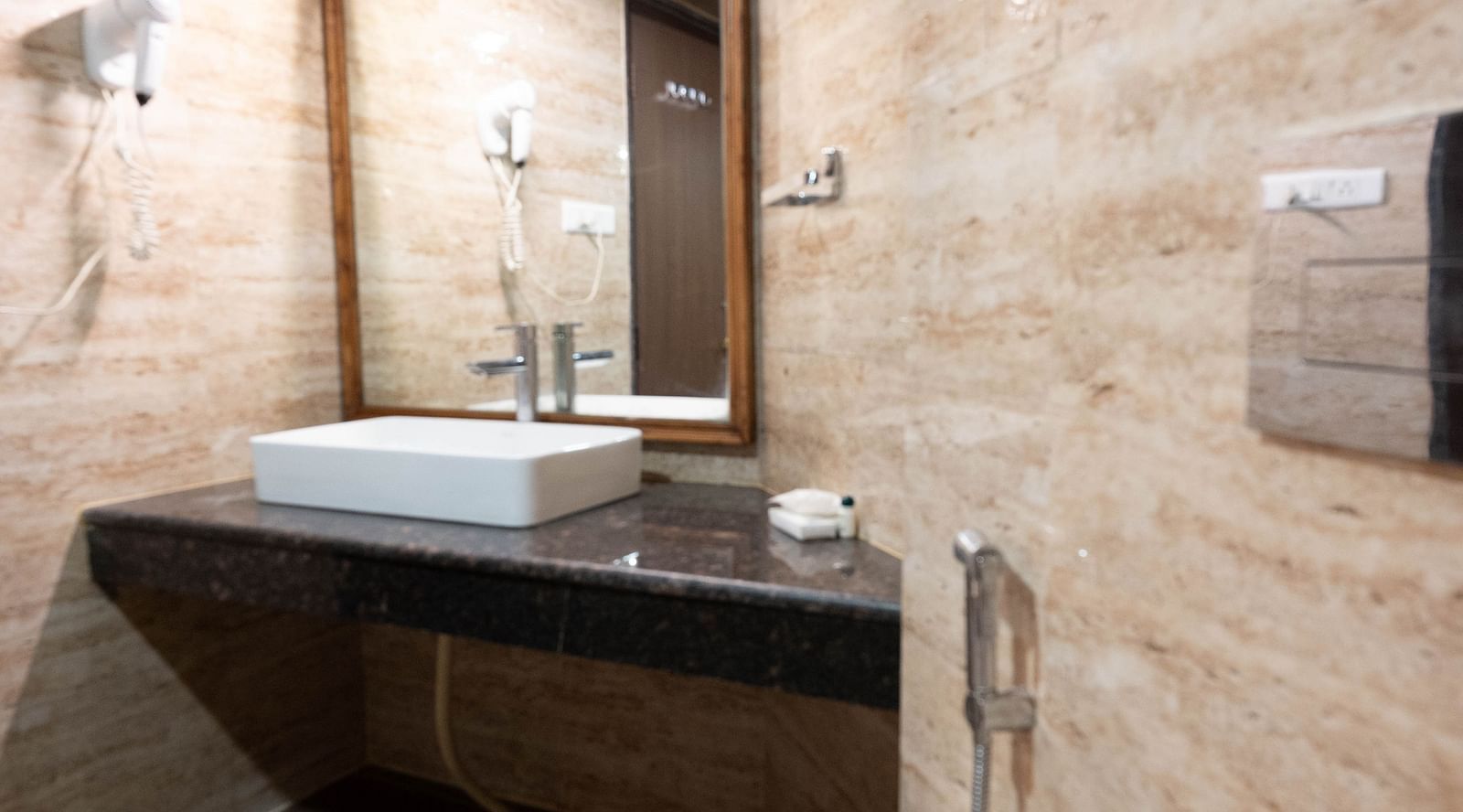 A bathroom with a wash basin and hair dryer at Avianna Hungry Jack, Gangtok.