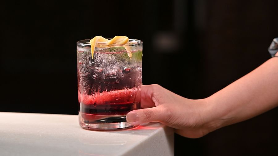 image of a hand reaching out and holding a glass of a cold beverage
