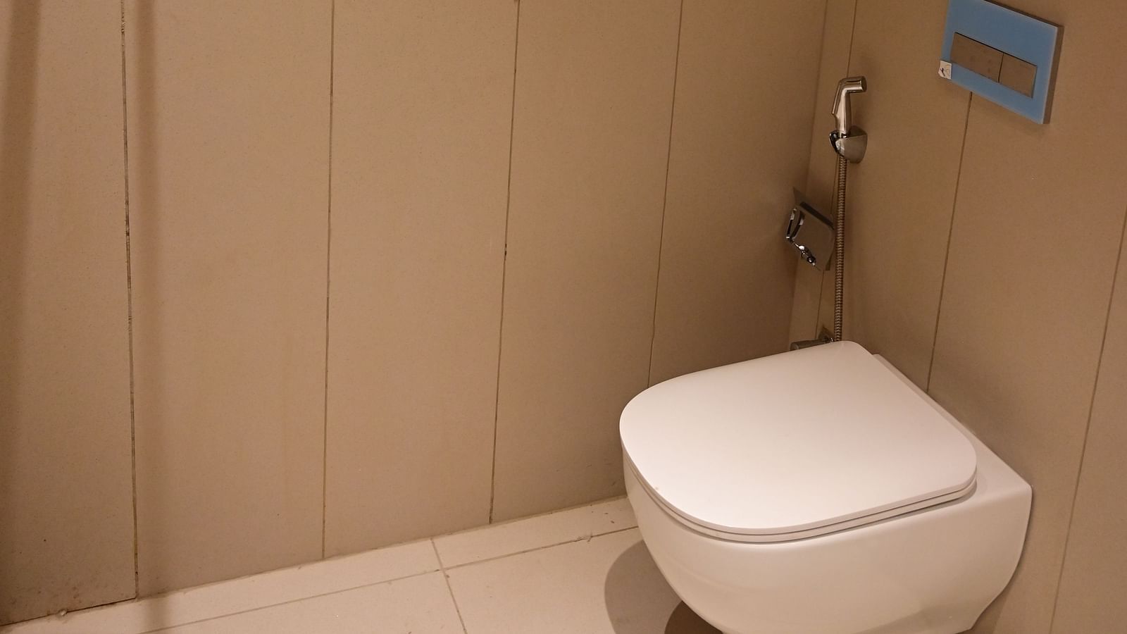 a modern bathroom featuring a commode at club charholi, pune