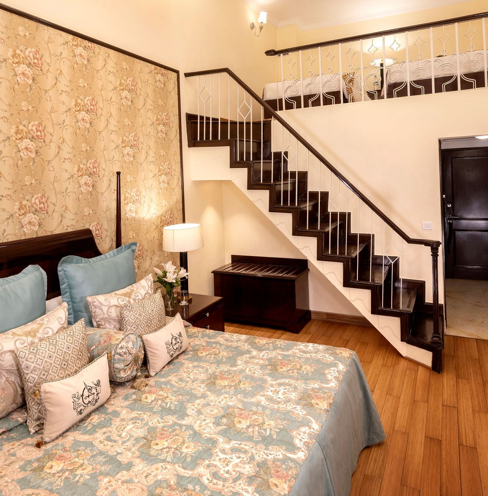 a brightly lit image of the Duplex Family Suite with a staircase leading to the upper floor at The Claridges Nabha Residence