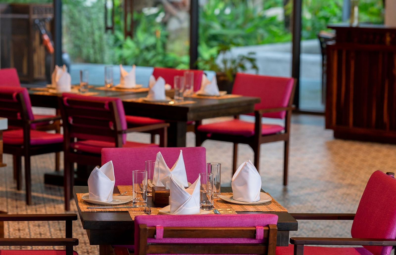 Maroon coloured chairs placed around tables at our restaurant - Alibu Resort Nha Trang